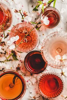 Verschiedene Weinsorten in Glässern auf einem Marmortisch.