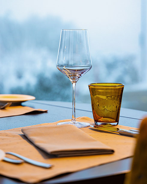 Ein Glas Wein auf einem Tisch neben einer Serviette und Besteck